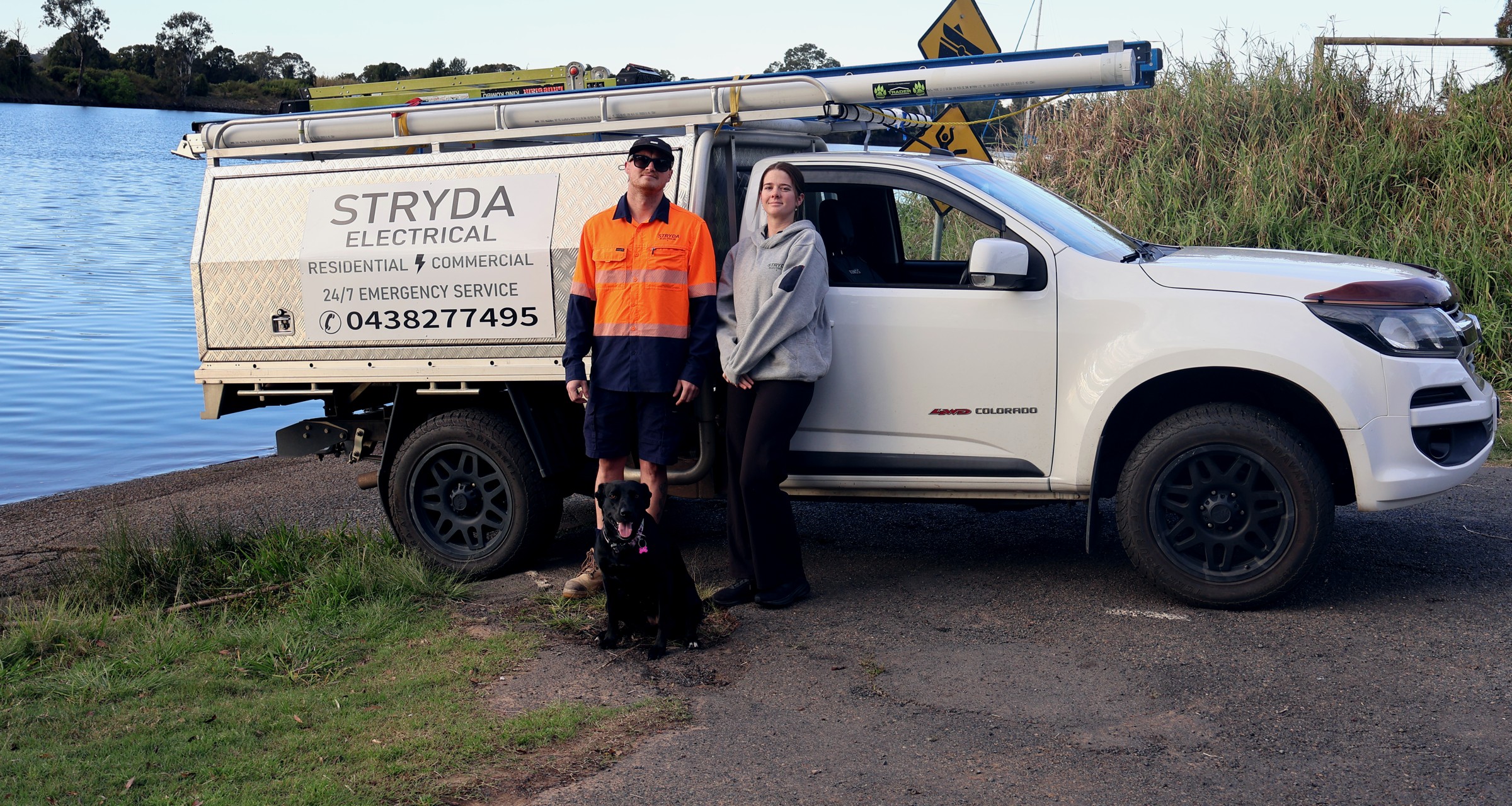 Josh and the Stryda Electrical team with Stryda the dog, beside the branded work ute